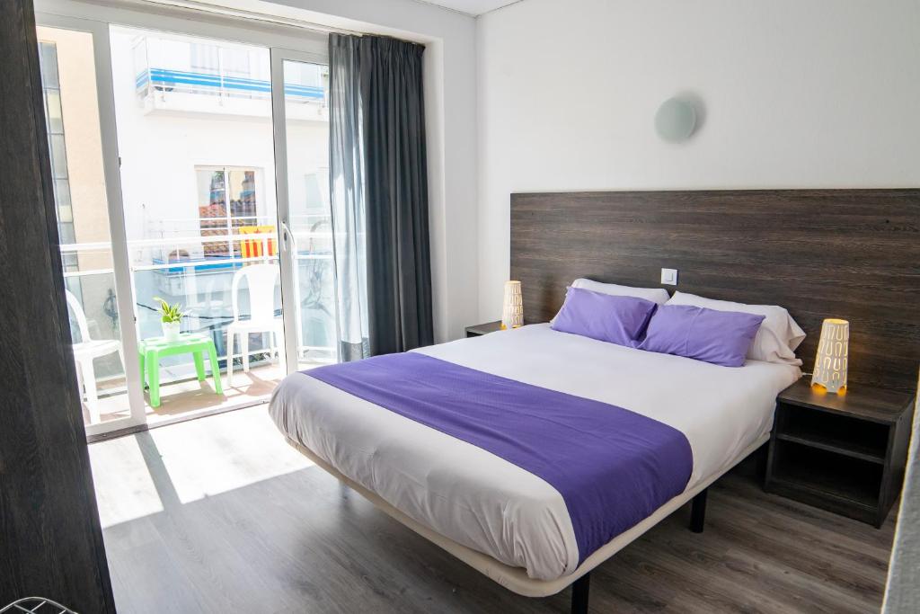 卡里拉阿萨瓦拉公寓式酒店的一间卧室配有一张带紫色枕头的大床
