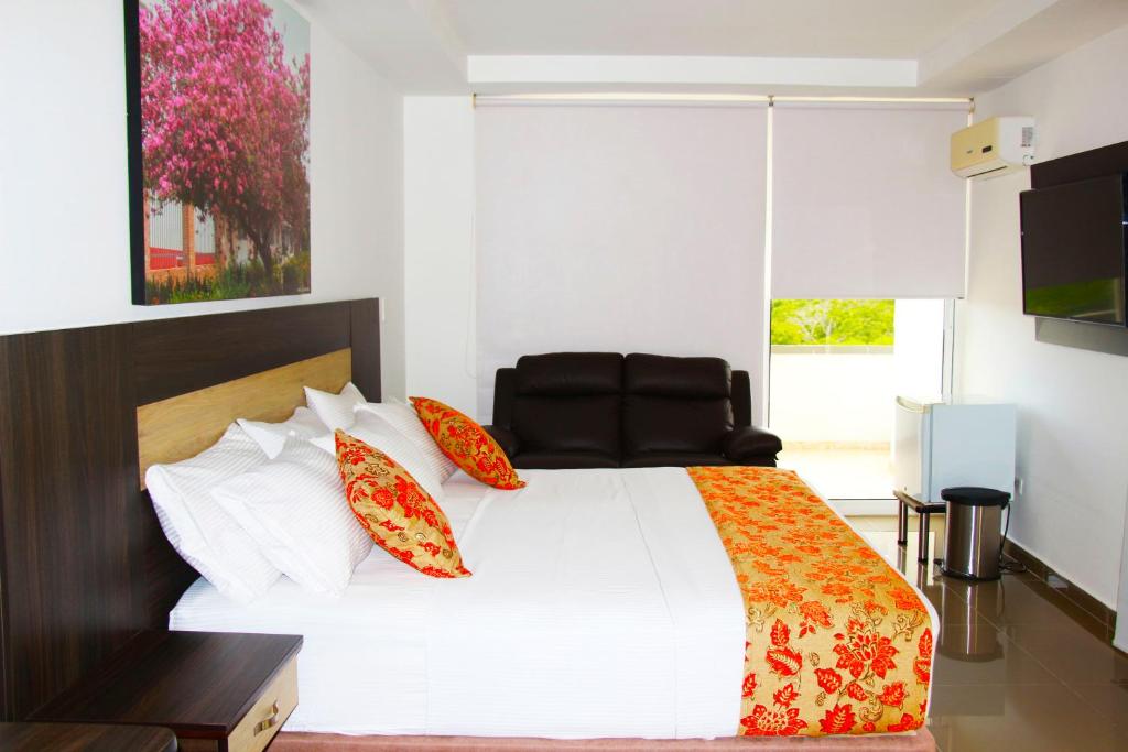 ManíHotel Anamela的卧室配有带红色枕头的大型白色床
