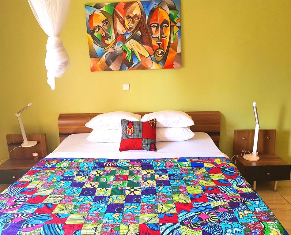 基加利Yambi Guesthouse的一间卧室,床上有五颜六色的被子