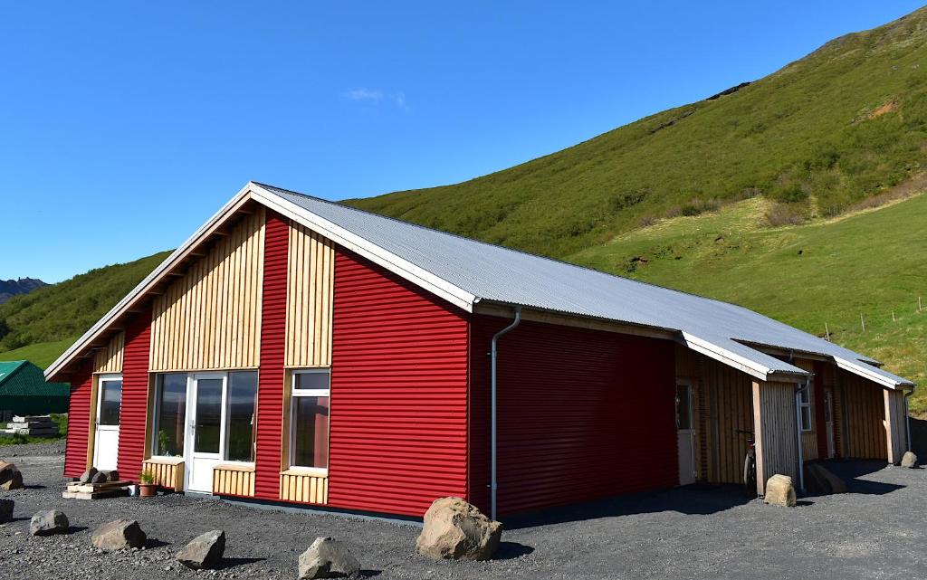 SvínafellThe Potato Storage的一座红色的建筑,后面有一座小山