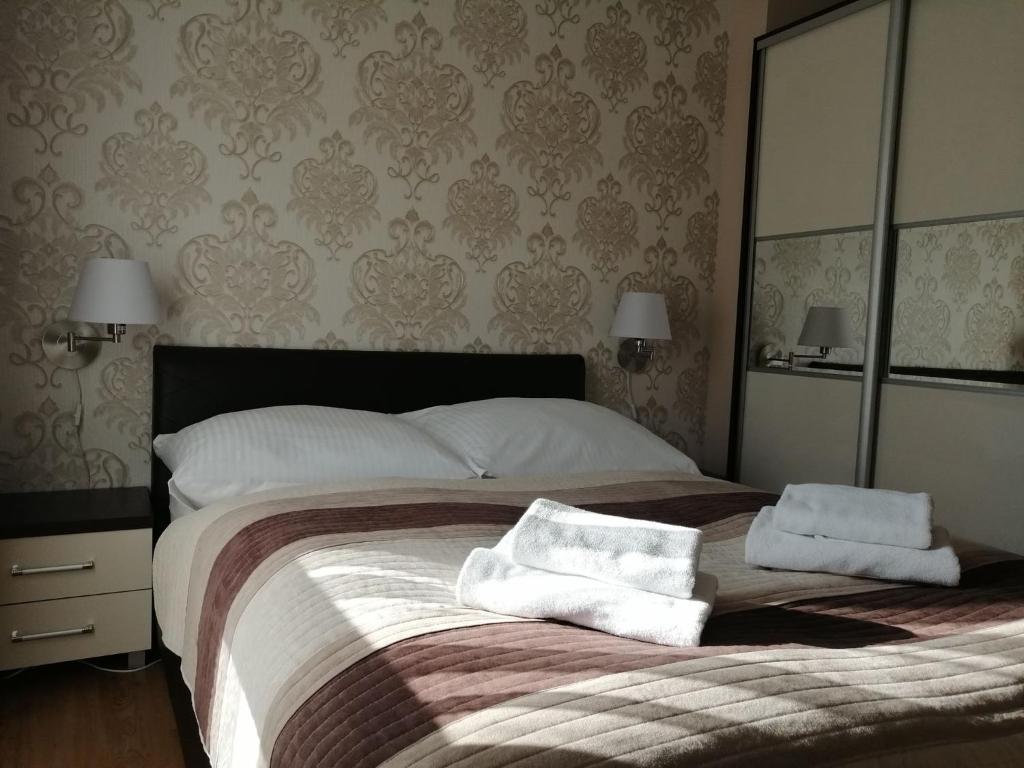 波别罗沃Apartament Mariva B03 z ogródkiem - Pobierowo - blisko morza - przy kompleksie Grand Laola SPA的一间卧室配有一张大床和两条毛巾
