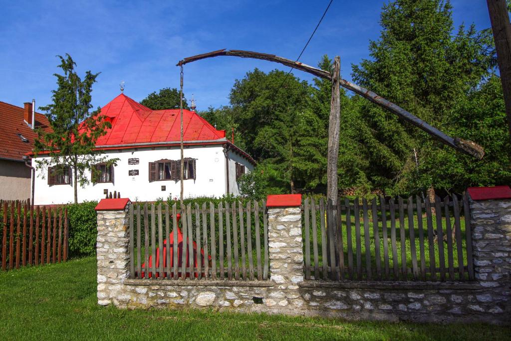 BalatonVén Diófa Kúria的白色房屋前的围栏,有红色屋顶