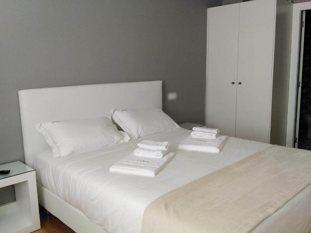 吉马良斯ALM SANTA LUZIA的一张白色的床,上面有三个枕头