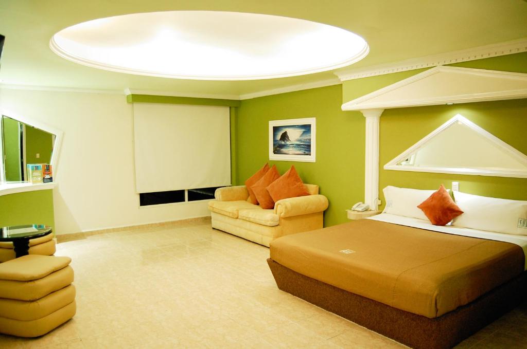 韦拉克鲁斯波托诺瓦酒店的一间卧室配有一张床和一个沙发