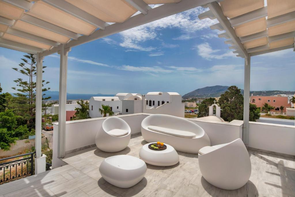 费拉苏拉别墅酒店的阳台配有白色椅子,享有城市美景