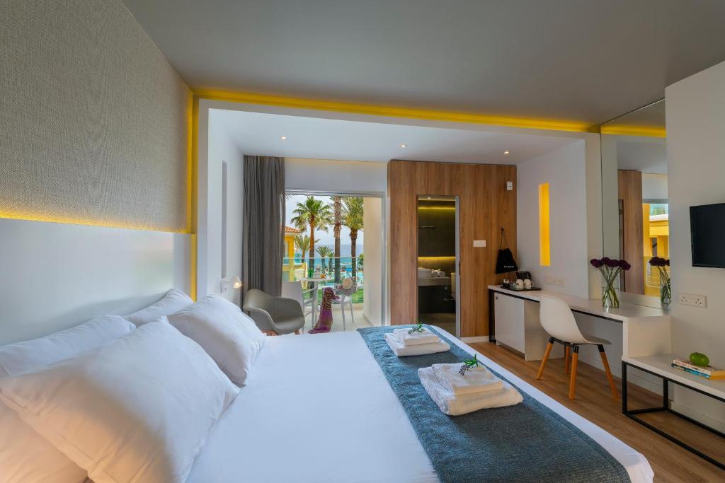 普罗塔拉斯玛拉玛海滩度假酒店的一间带白色大床的卧室和一间厨房