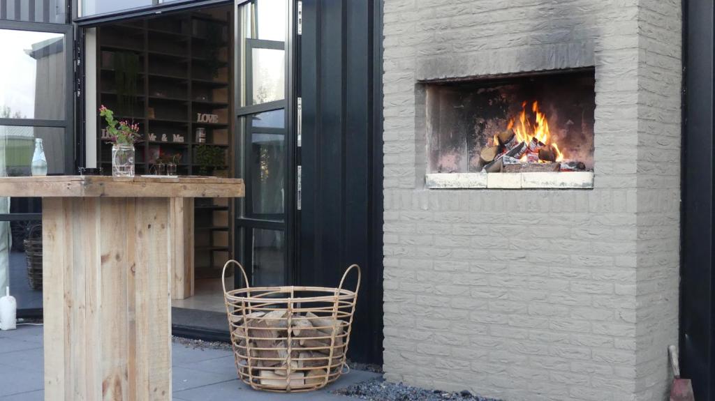 斯哈伦代克Vakantiehuizen 7Huizen aan Zee的壁炉,位于带长凳的建筑的一侧