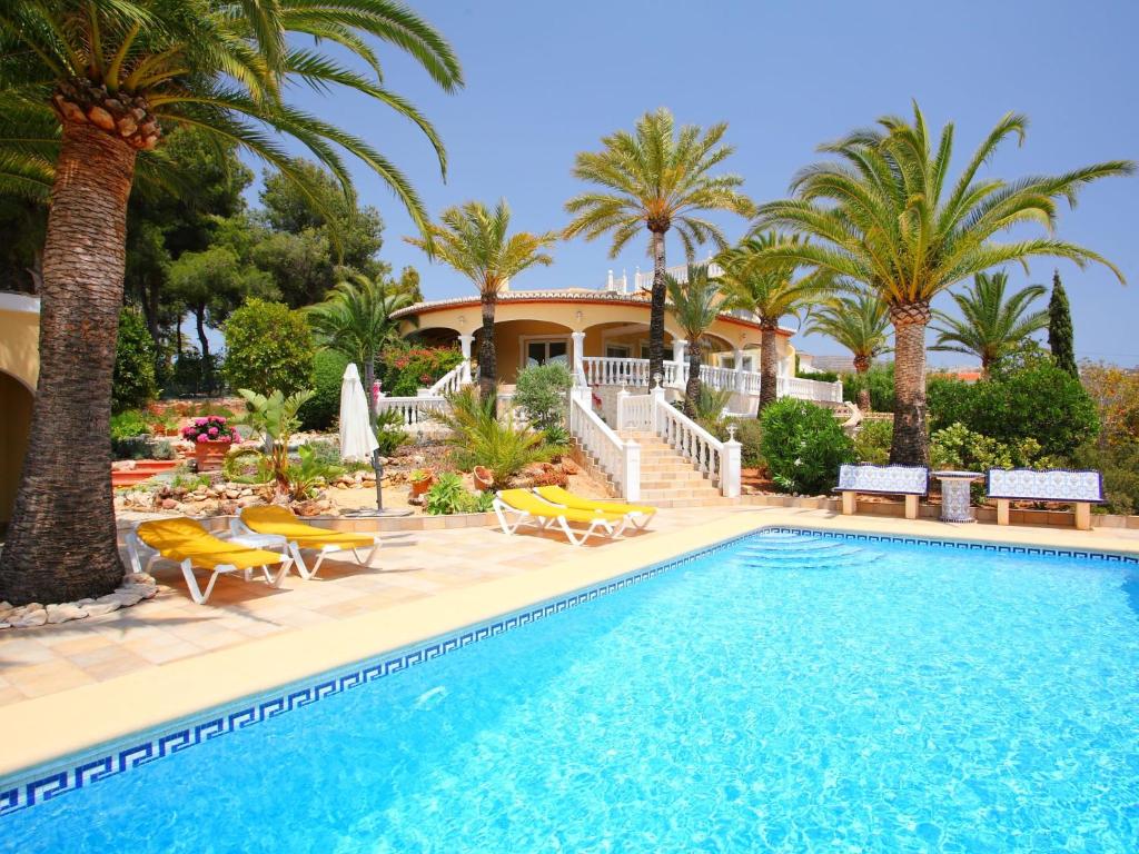 莫莱拉Villa Bombilla by Interhome的一座别墅,设有游泳池和棕榈树