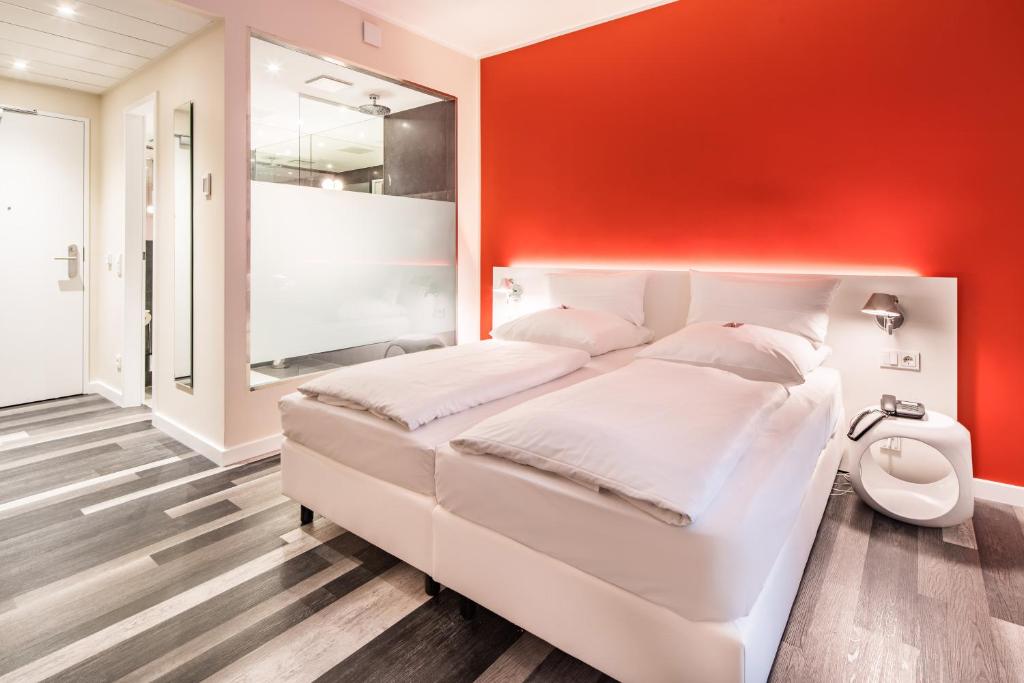 汉诺威蒂伦广场城市酒店的卧室配有白色的床和红色的墙壁
