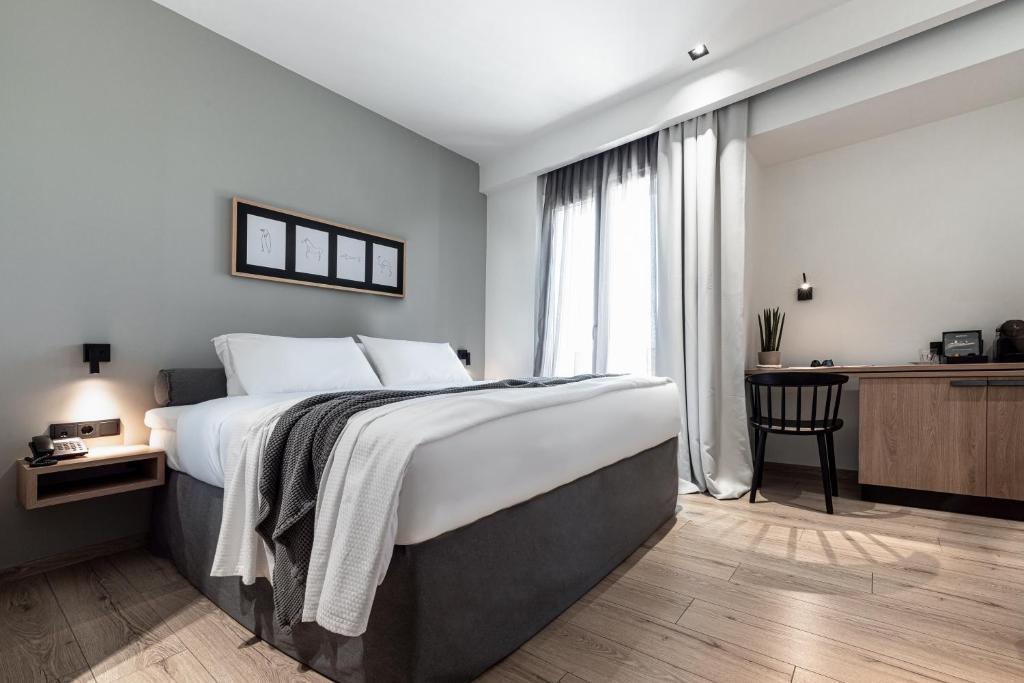亚历山德鲁波利斯31 Doors Hotel的一间卧室配有一张床、一张书桌和一个窗户。