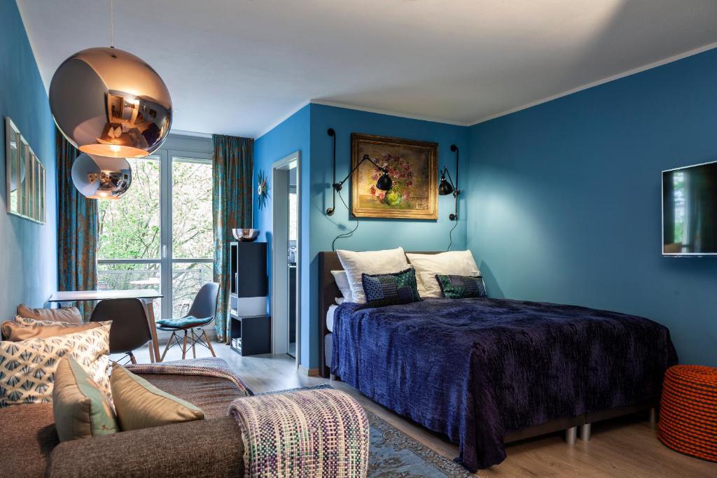 德累斯顿Studio Apartment in Dresden-Neustadt的蓝色的卧室配有床和沙发