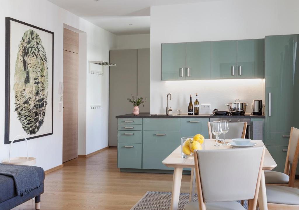 西兰德罗Sommavilla Apartments - central living的厨房配有绿色橱柜和桌椅