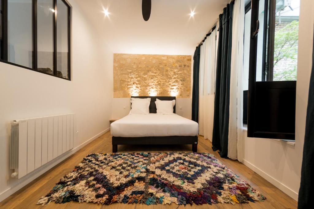 波尔多AMA的一间卧室配有一张床、一台电视和一张地毯。