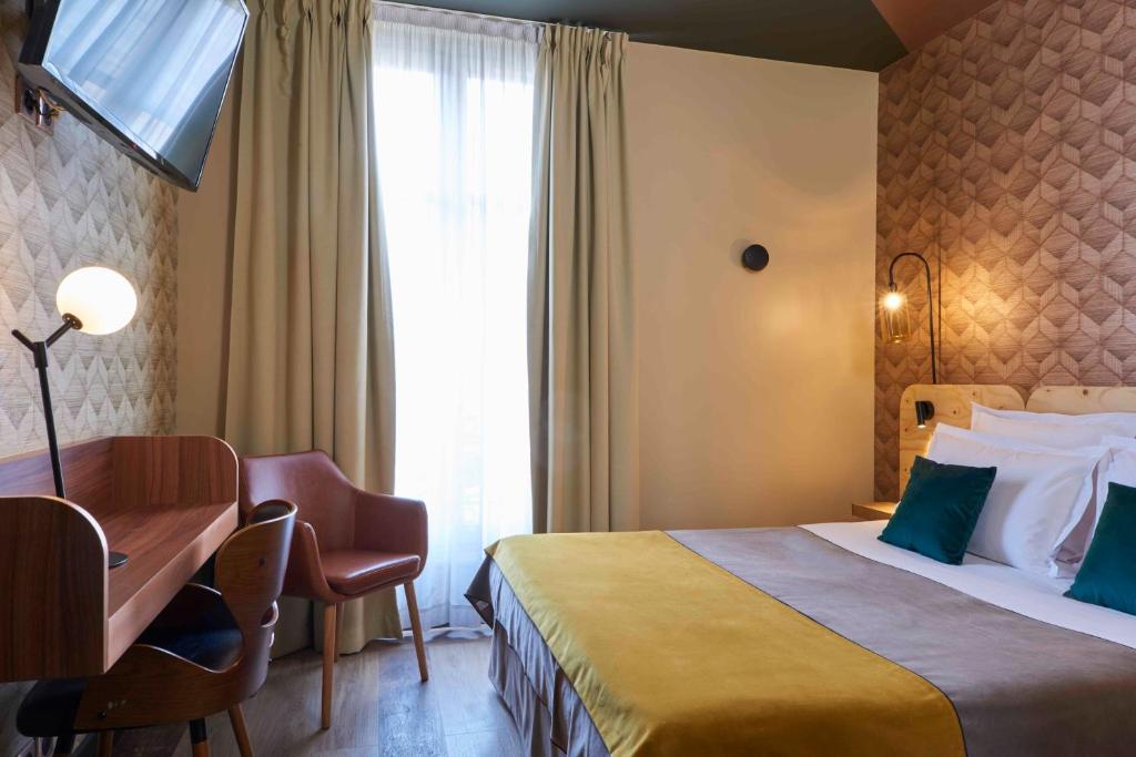 波尔多快乐文化柯迪酒店的配有一张床、一张书桌和一扇窗户的酒店客房
