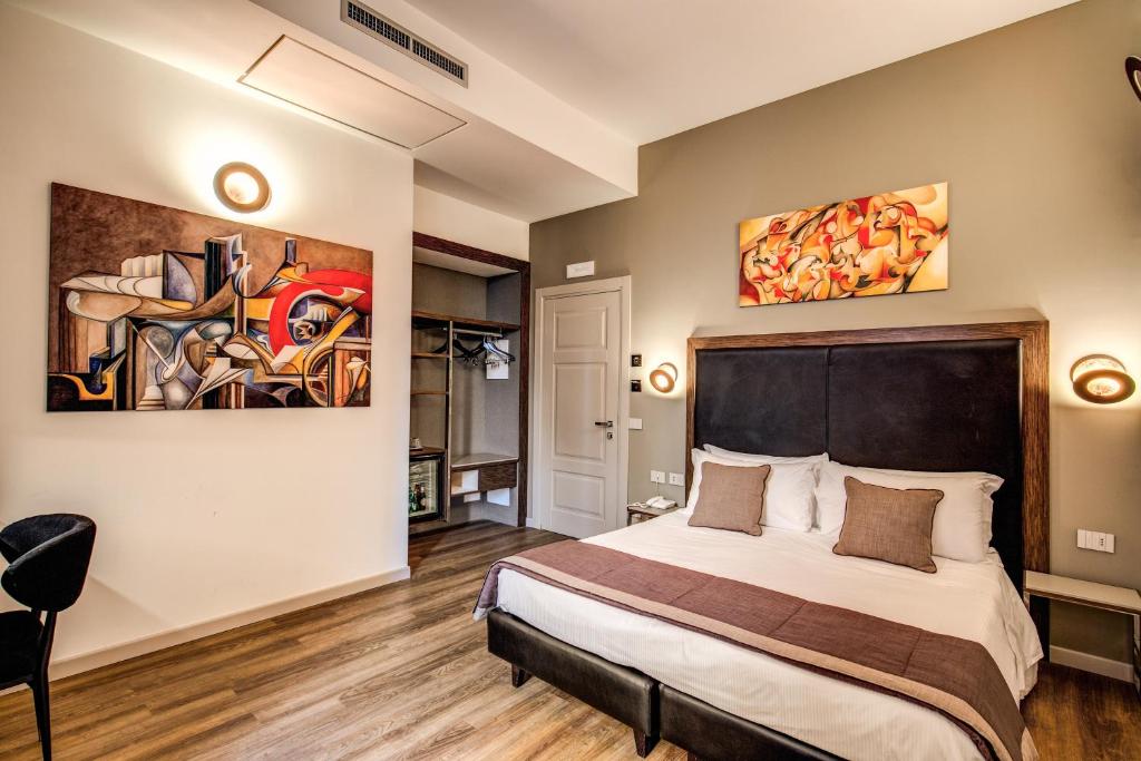 罗马Al Manthia Hotel - Gruppo Trevi Hotels的卧室配有一张床,墙上挂有绘画作品