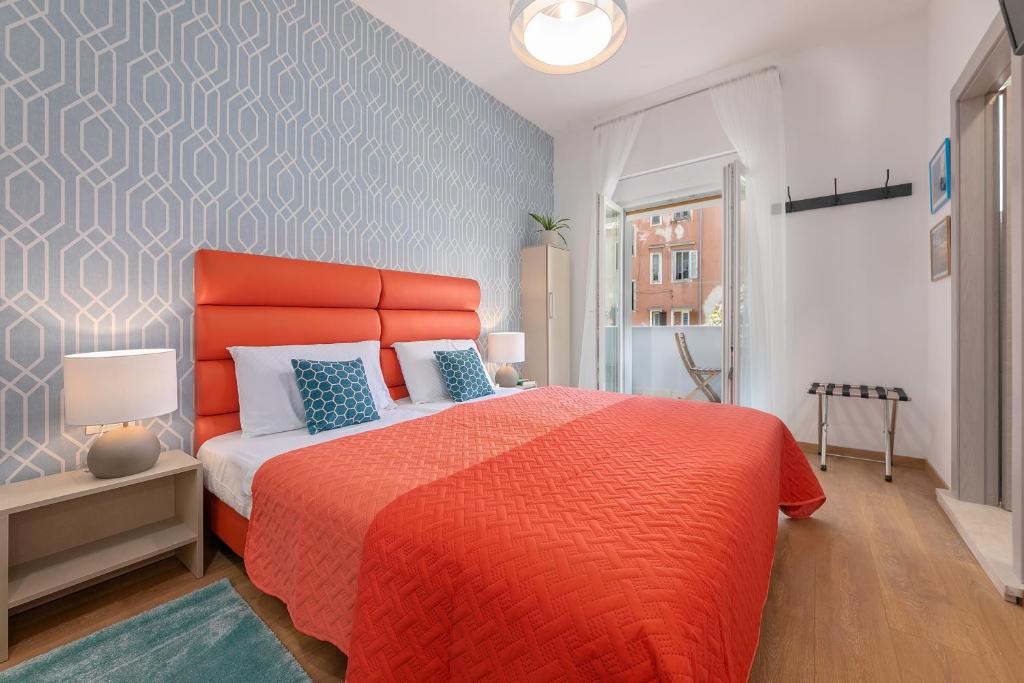 普拉La Preziosa Rooms的一间卧室配有一张带橙色床罩的大床
