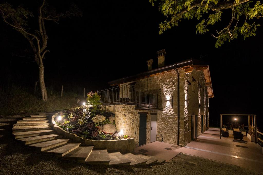 ZoneAgriturismo Casarai的一座石头建筑,晚上有楼梯和灯光