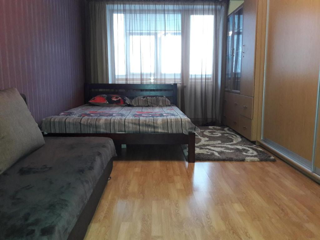 切尔尼戈夫Апартаменты в центре的一间卧室设有两张床、一张沙发和一个窗口