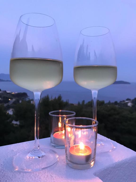 瓦西里亚斯Andreas Village的桌子上放两杯白葡萄酒和蜡烛