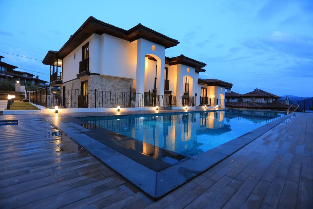 阿奇亚卡Verde Suites Akyaka的夜间带游泳池的别墅