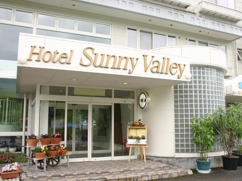 小谷村阳光谷酒店 的大楼前的酒店即兴瓦利标志
