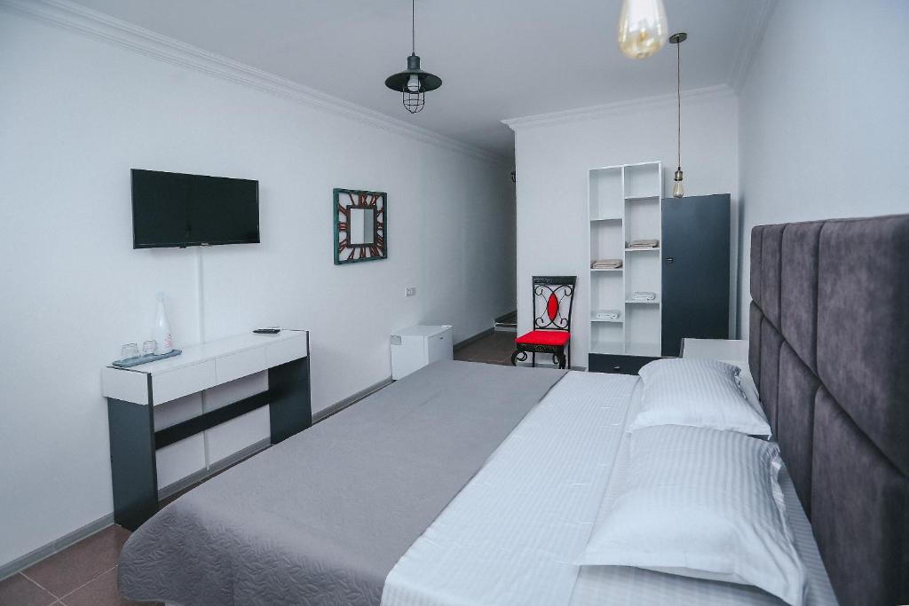 库塔伊西Hotel Tamar Mepe的一间卧室配有一张床、一张书桌和一台电视。