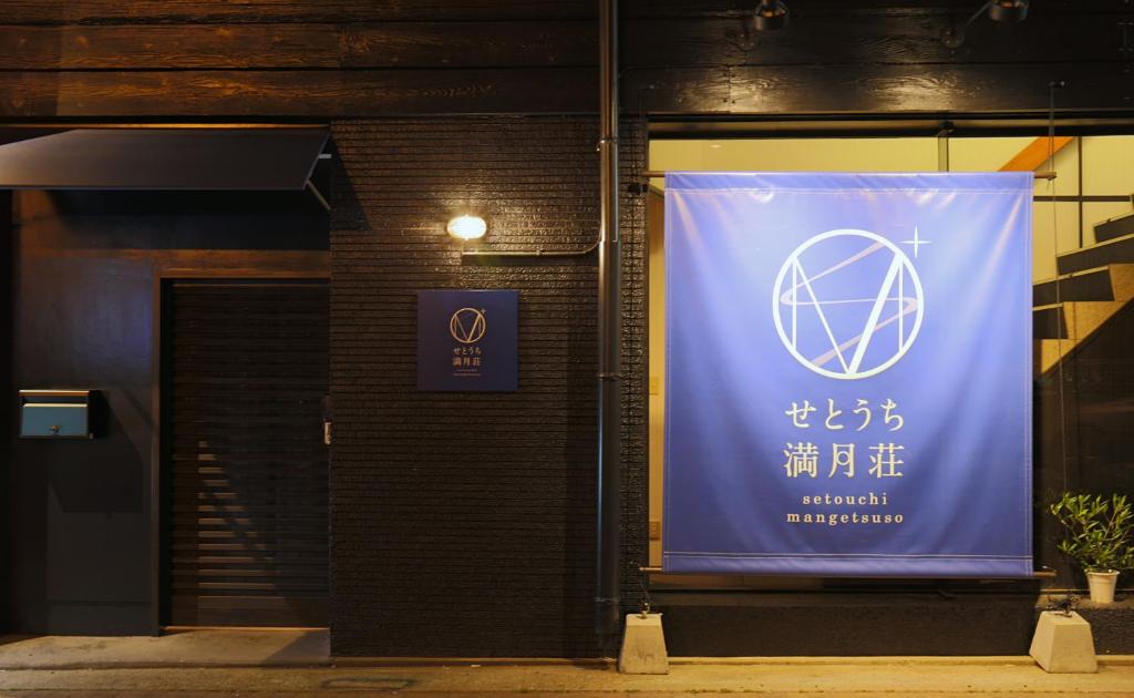 高松Setouchi Mangetsuso的建筑物边的横幅,带有标志