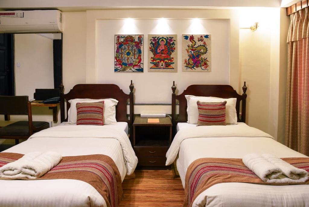 加德满都尼泊尔亭台酒店的一间卧室配有两张带毛巾的床