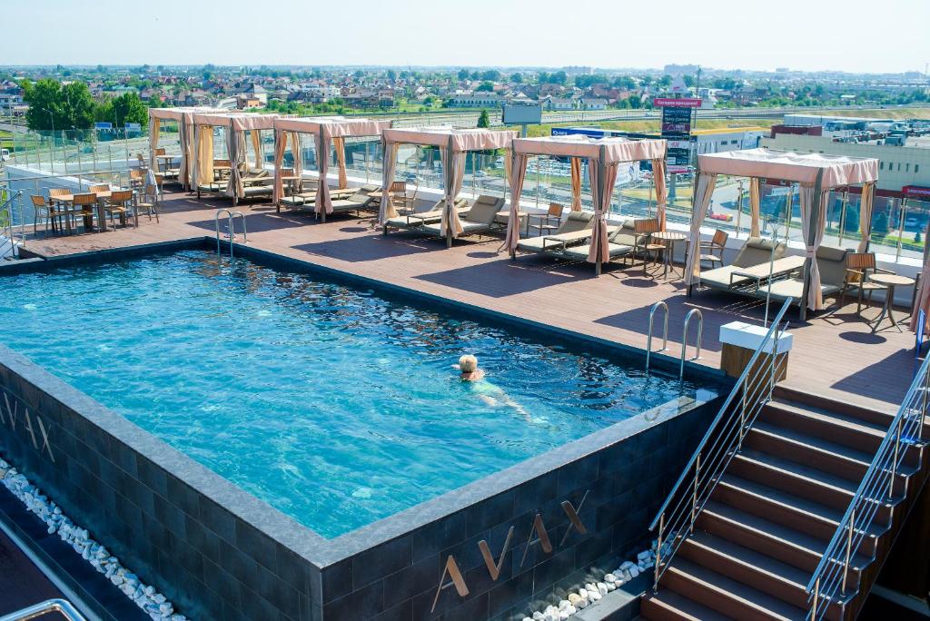 克拉斯诺达尔Grand Spa Hotel Avax的在度假村游泳池游泳的人