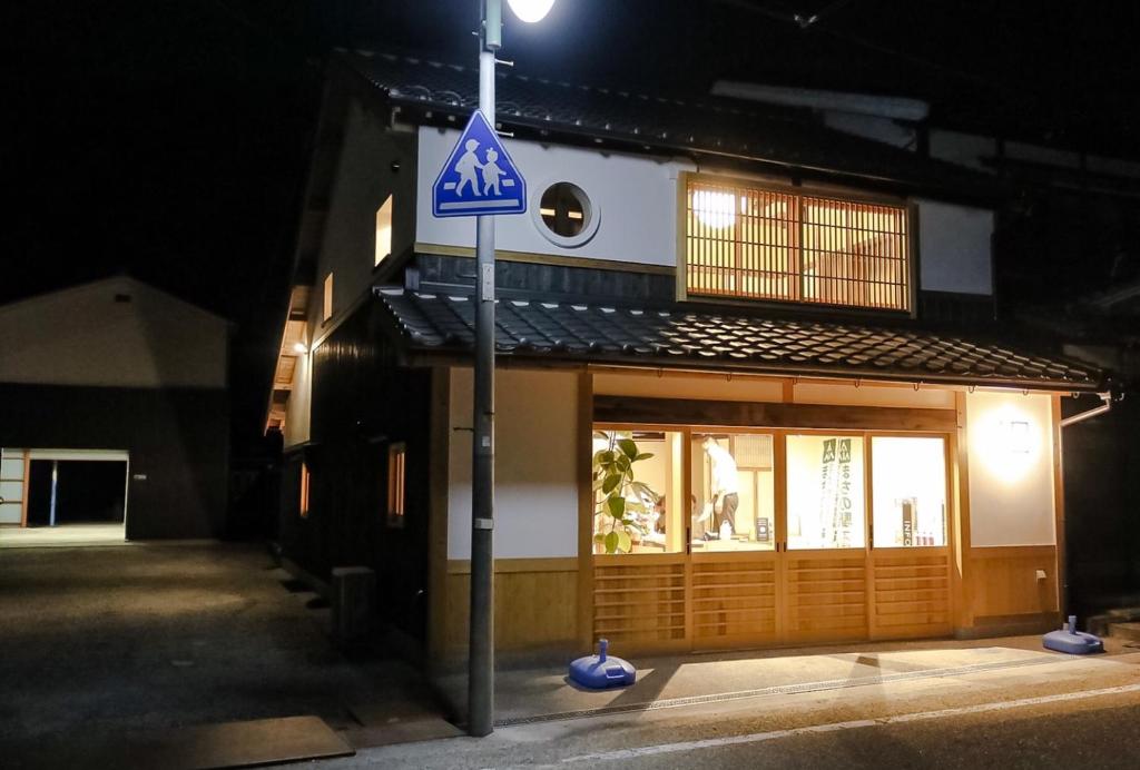 Shimo-azae北房まちの駅 ゲストハウス的夜间在建筑物前的街道标志