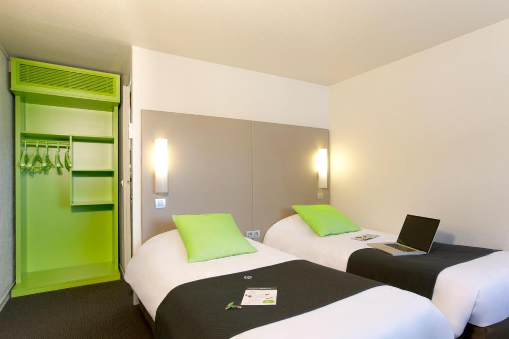 布雷斯特布雷斯特钟楼酒店 - 古埃斯努机场酒店的配有笔记本电脑的房间的两张床