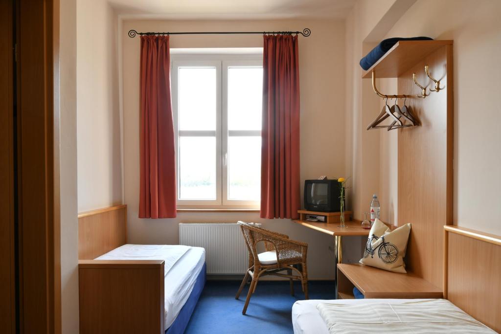 巴特迪克海姆Gästehaus & Café Leeze的酒店客房设有两张床、一张书桌和一个窗户。