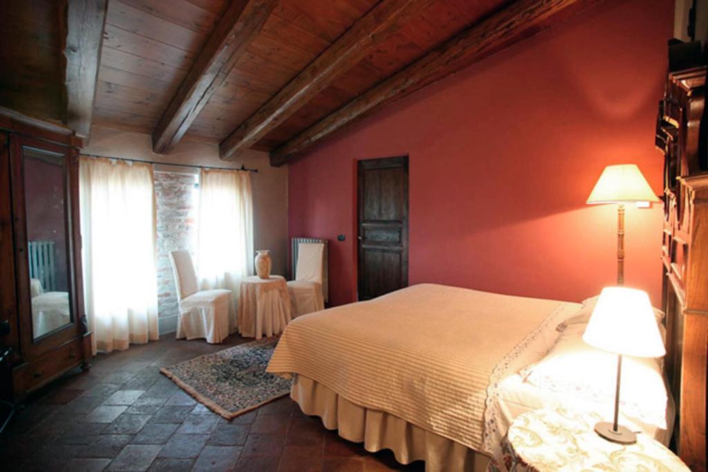 Neviglie丁迪纳农家乐的卧室配有白色的床和红色的墙壁