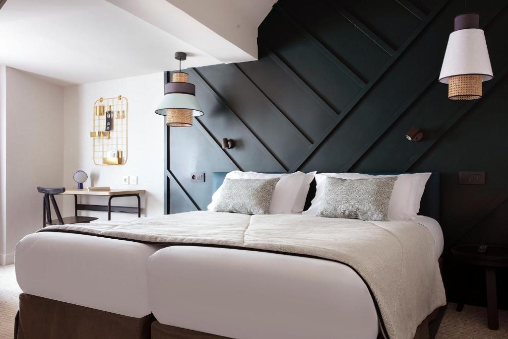 巴黎巴斯提尔斯佩利亚酒店的一间卧室配有一张白色大床和黑色墙壁