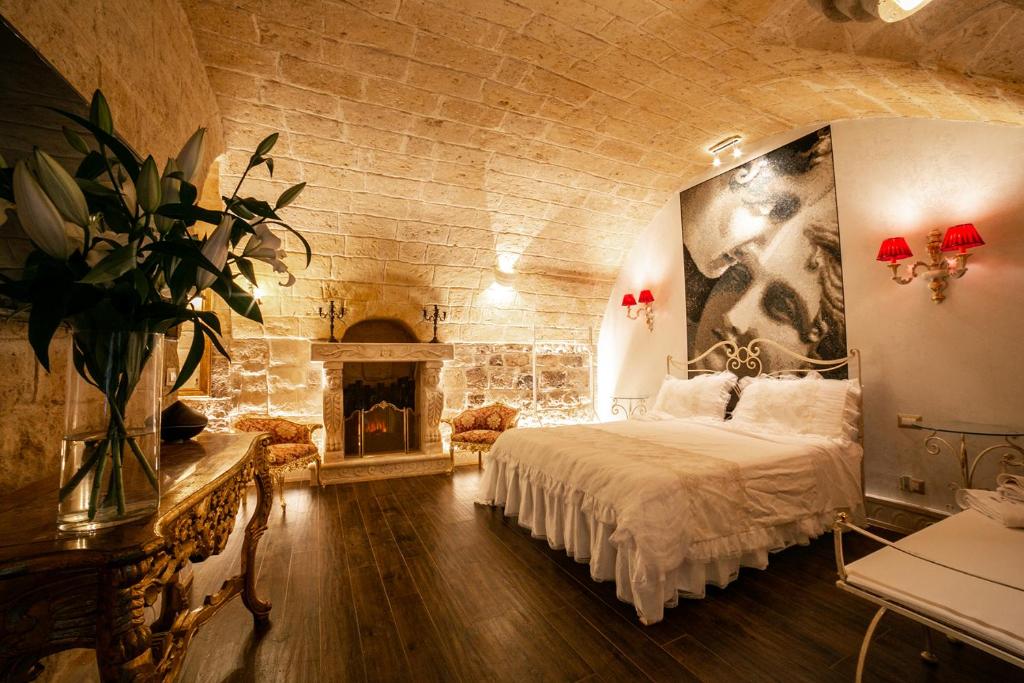 特拉尼L' alcova di Federico的一间卧室设有一张大床和一个壁炉