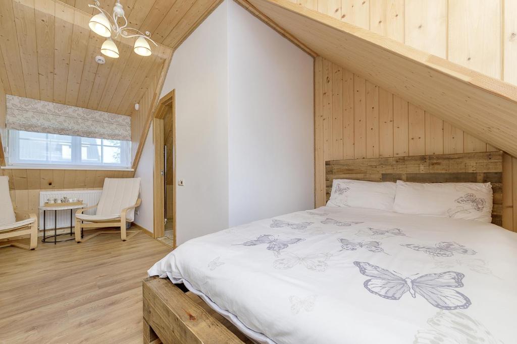 特拉凯Prie Lukos ezero的卧室配有一张床铺,位于带木墙的房间内