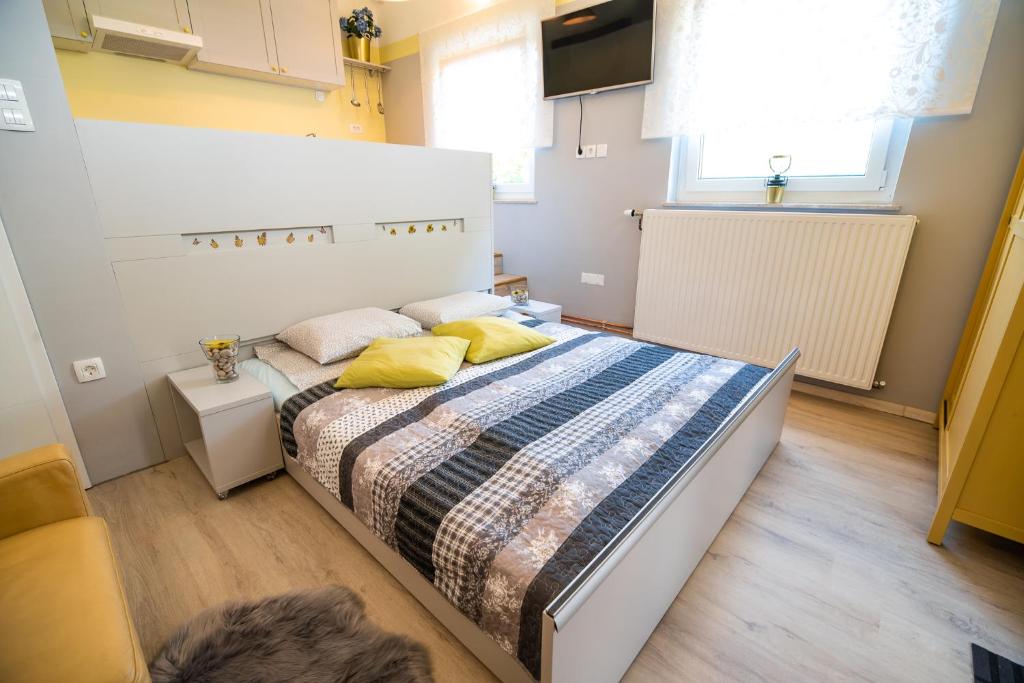 Krška VasApartments Stankovo的一间卧室配有一张带黄色枕头的大床