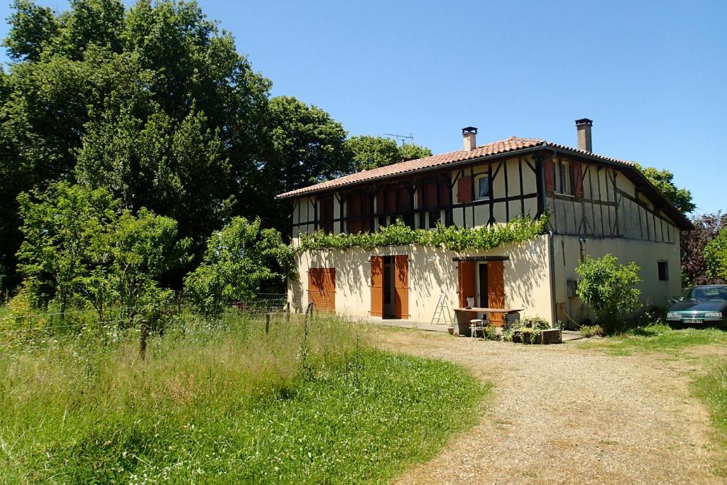 MomuyRicouch, chambre d'hôtes et permaculture的一座有藤蔓的老房子