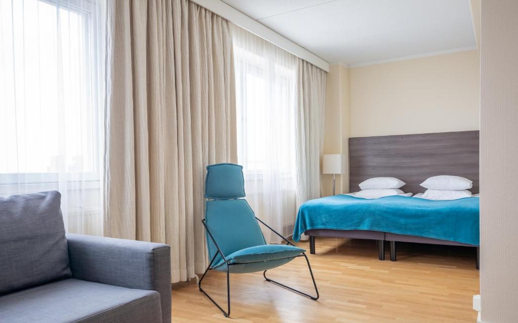 波里Torget Aparthotel的一间卧室配有一张床、一把椅子和一张沙发