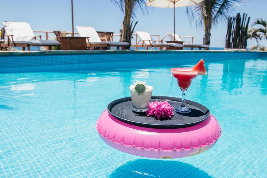 卡诺阿斯德蓬萨尔Baja Canoas Hotel的在游泳池的浮舟上喝一杯,喝一杯玛格丽塔