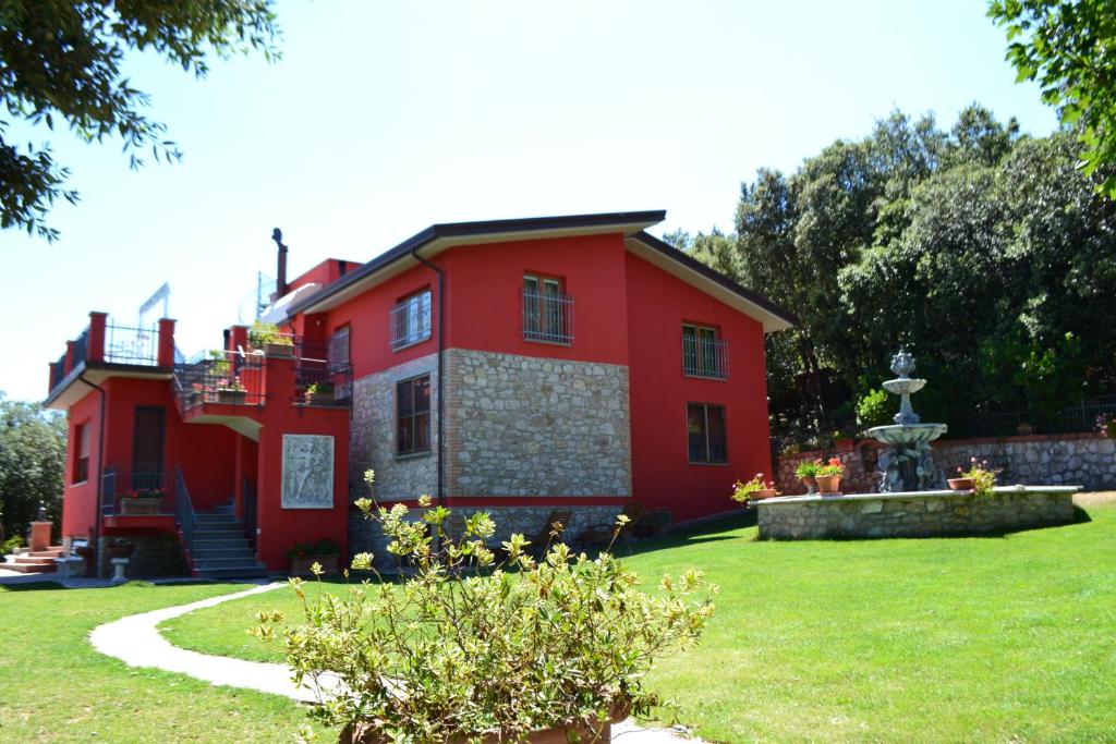 佩鲁贾春天住宿加早餐酒店的院子里有喷泉的红色房子