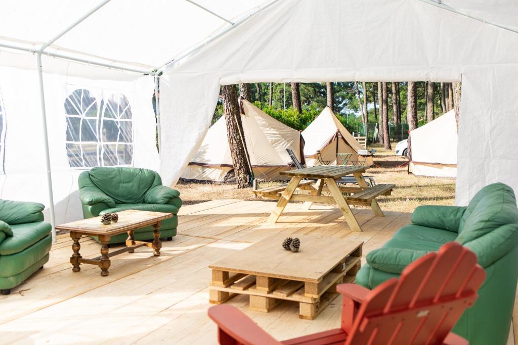 比斯卡罗斯The Spot Surfcamp的配有两张沙发和一张桌子及椅子的帐篷