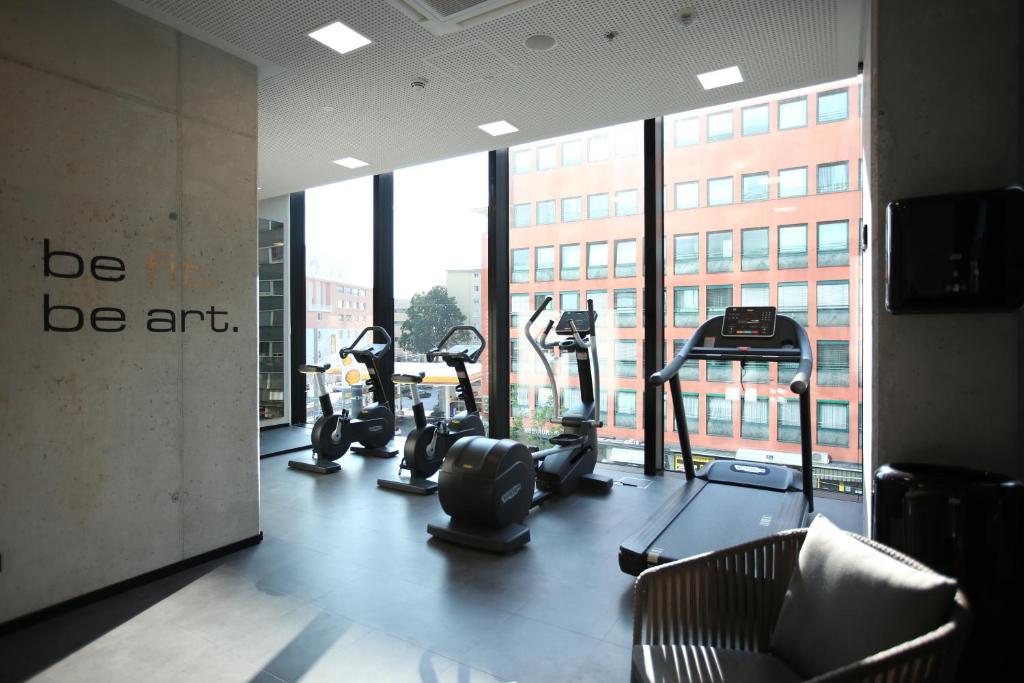 萨尔茨堡arte Hotel Salzburg的带有氧器材的健身房,位于带窗户的房间内