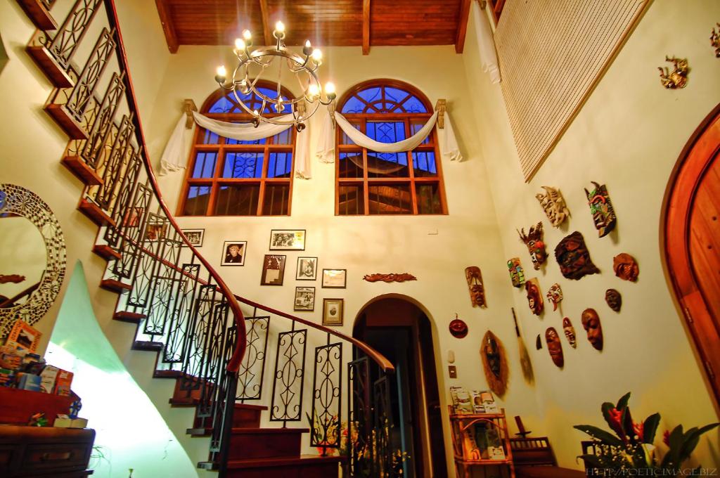 圣何塞卡里阿利住宿加早餐旅馆的墙上有一堆照片的房子里的楼梯