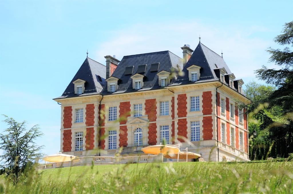 BoncourtDomaine de Mont-Renaud的黑色屋顶的大型砖砌建筑