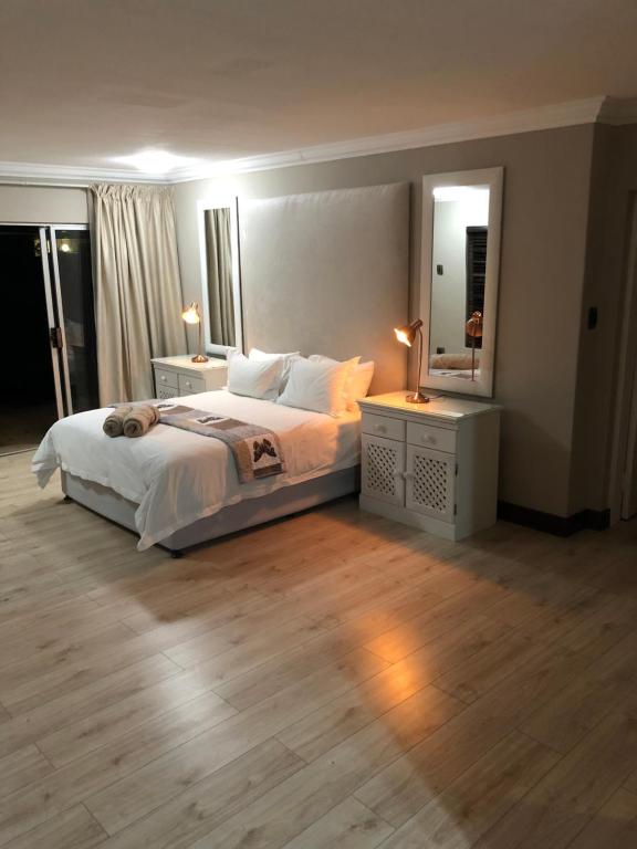 肯普顿帕克Annies Place Self Catering的一间卧室配有一张带2个床头柜和镜子的床