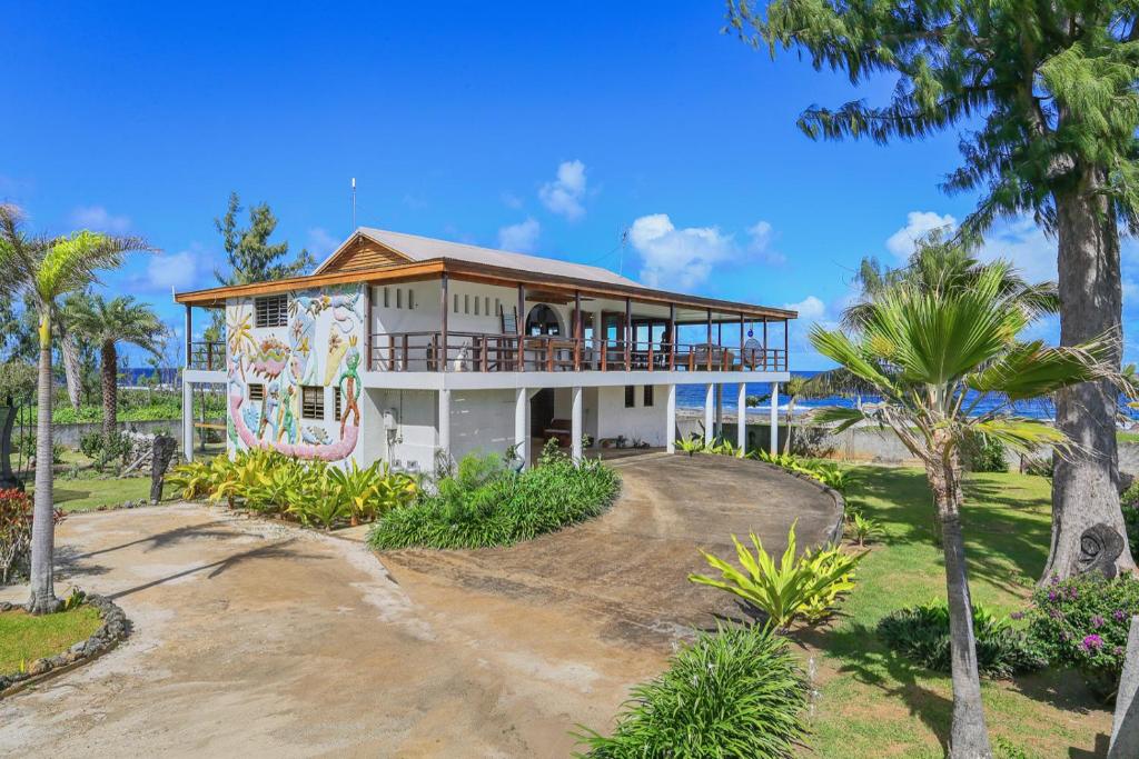 PoussabierVilla Senang Masari的棕榈树海滩上的房子