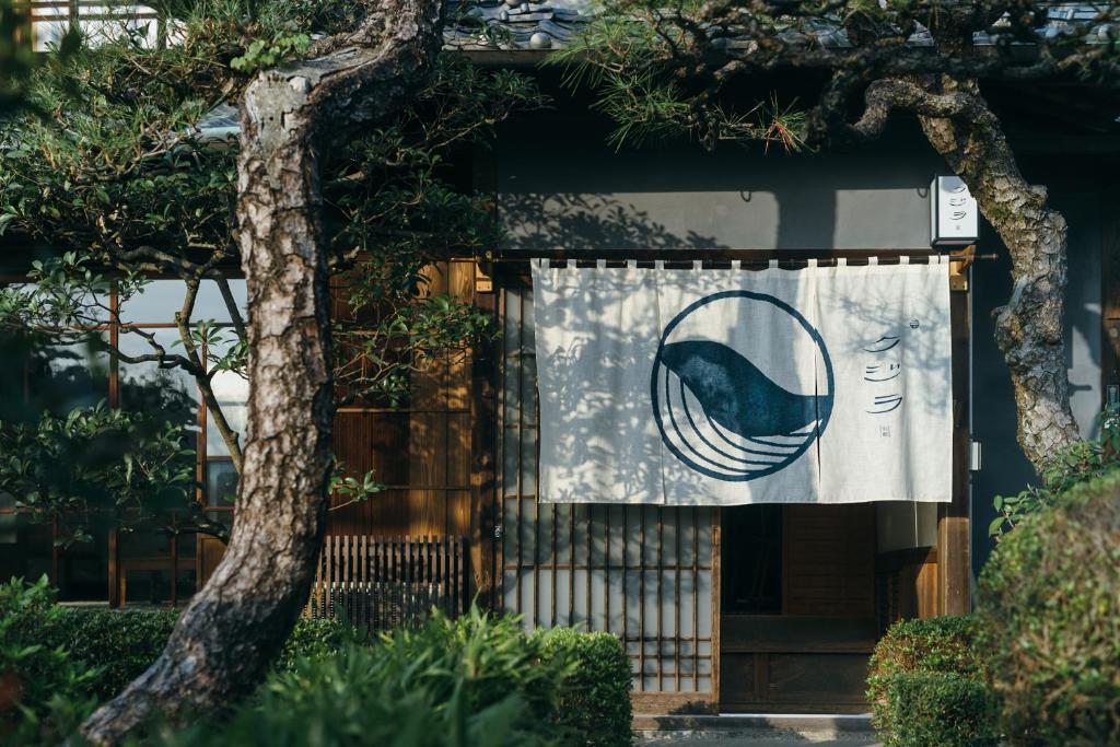 尾道市クジラ別館的建筑物边的标牌,带窗帘