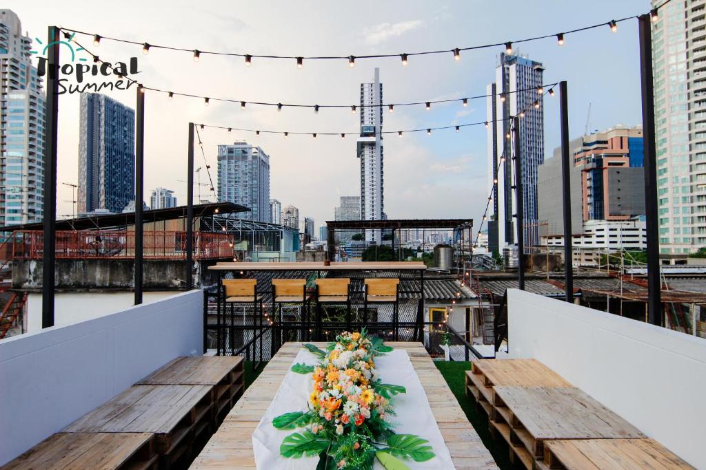 曼谷Tropical Summer Hostel的屋顶上的桌子,享有城市美景