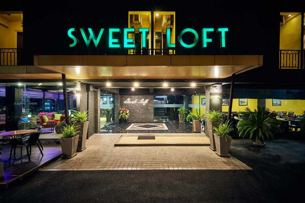 曼谷Sweetloft Hotel Don Muang的餐厅的夜景,带有可读到甜蜜电梯的标志